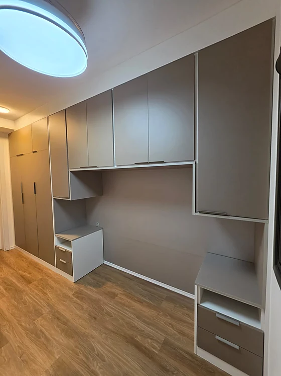 Home office com bancada e armários aéreos