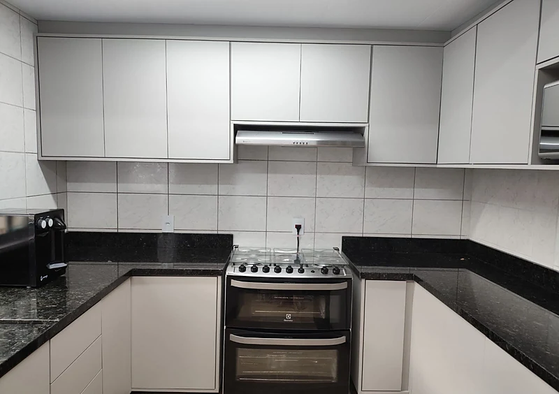 Cozinha planejada em L com bancada de granito